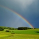 A picture of a pasture in upstate new york after a thunderstorm with a rainbow in the sky, this image is used to teach about the weather in Spanish language instruction NYC